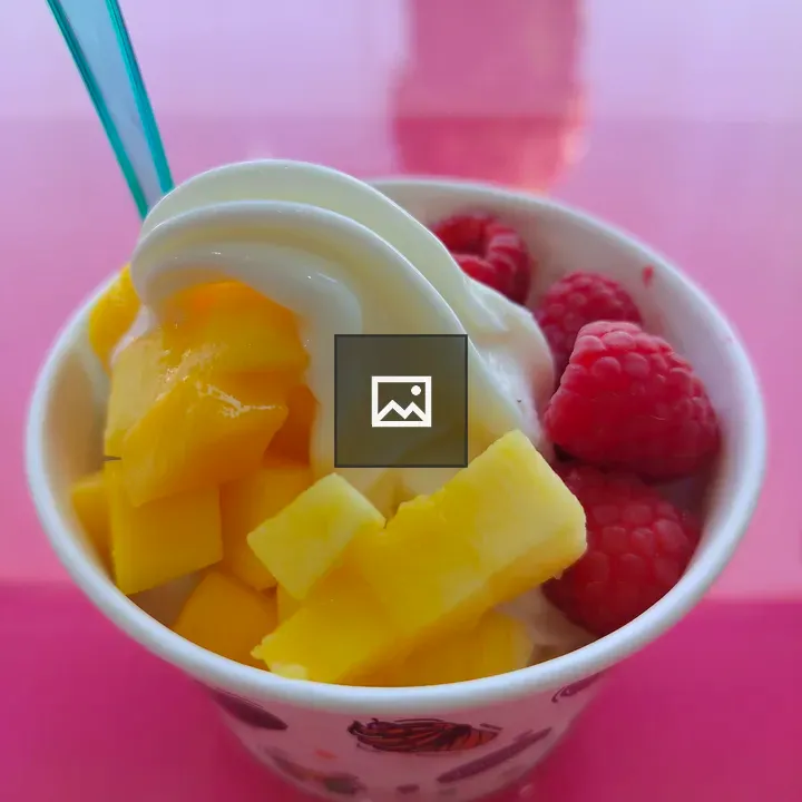 Paper cup of frozen yogurt with fruit