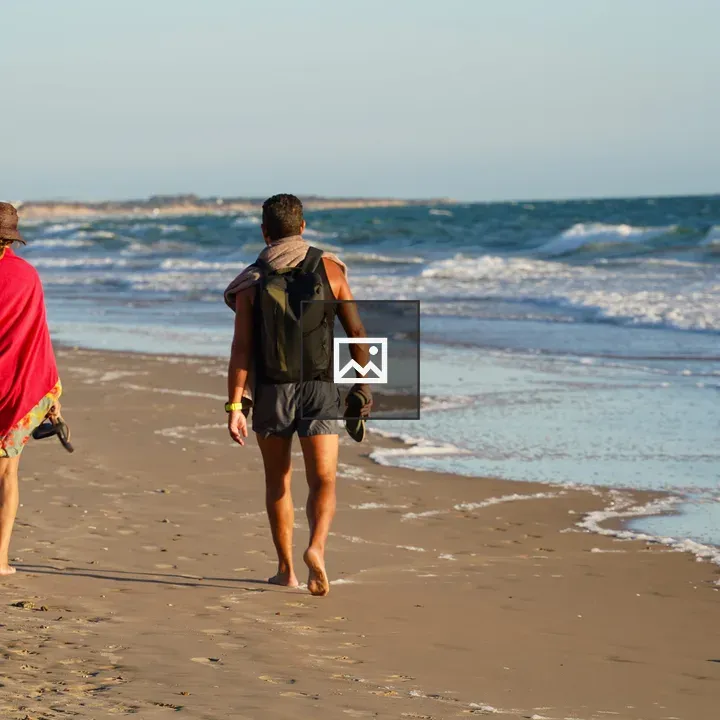 Two barefoot walkers on the beach
