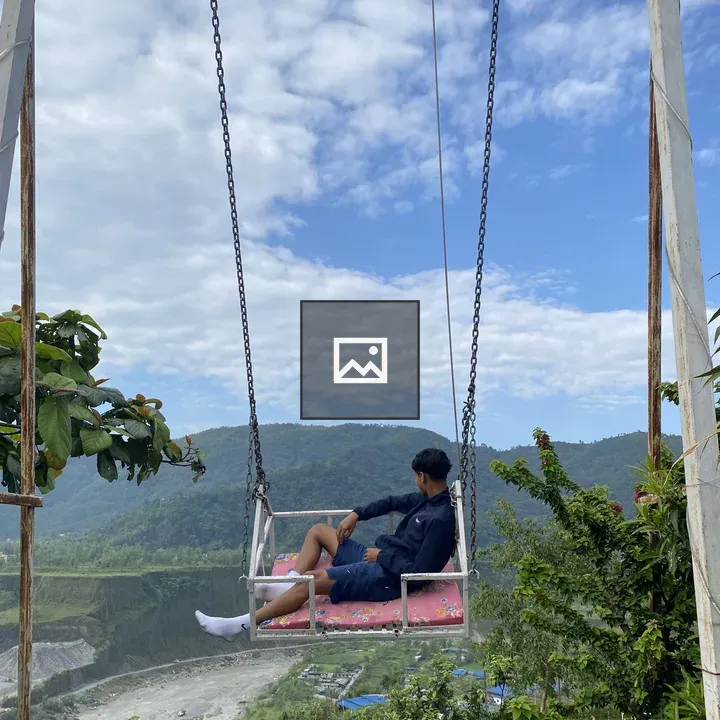 Person on Swing Over Scenic Landscape