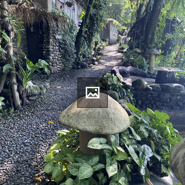 Path through greenery to rustic buildings