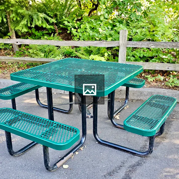 Green picnic table under trees