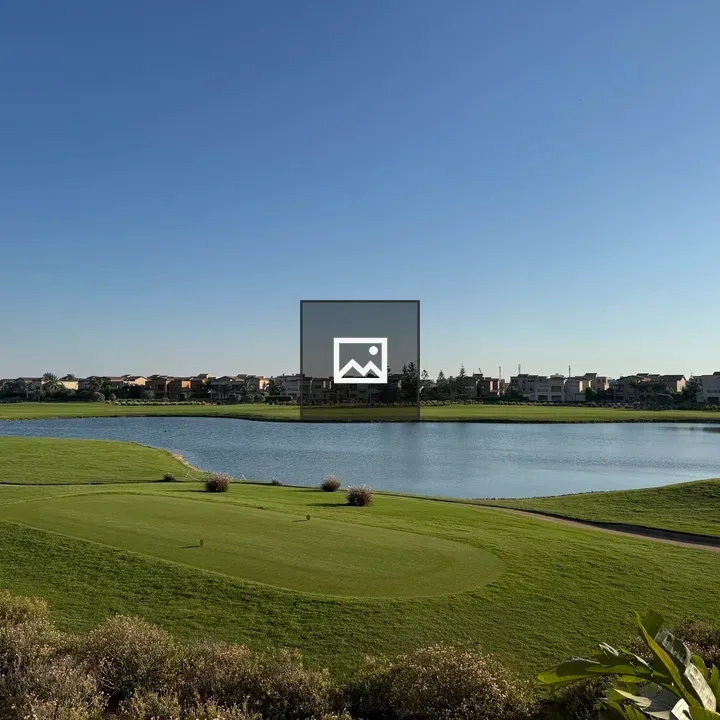 Golf field view with houses and pond