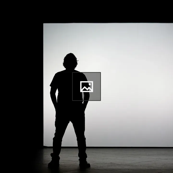 Person silhouette in front of bright screen