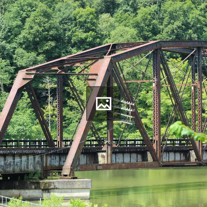 Rusted iron train bridge over water