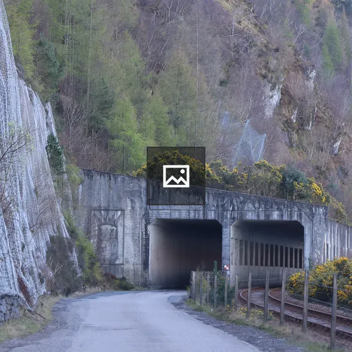 Winding road to concrete tunnel