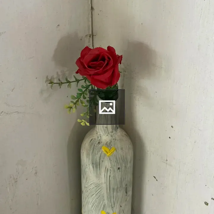 Glass bottle with rose in corner
