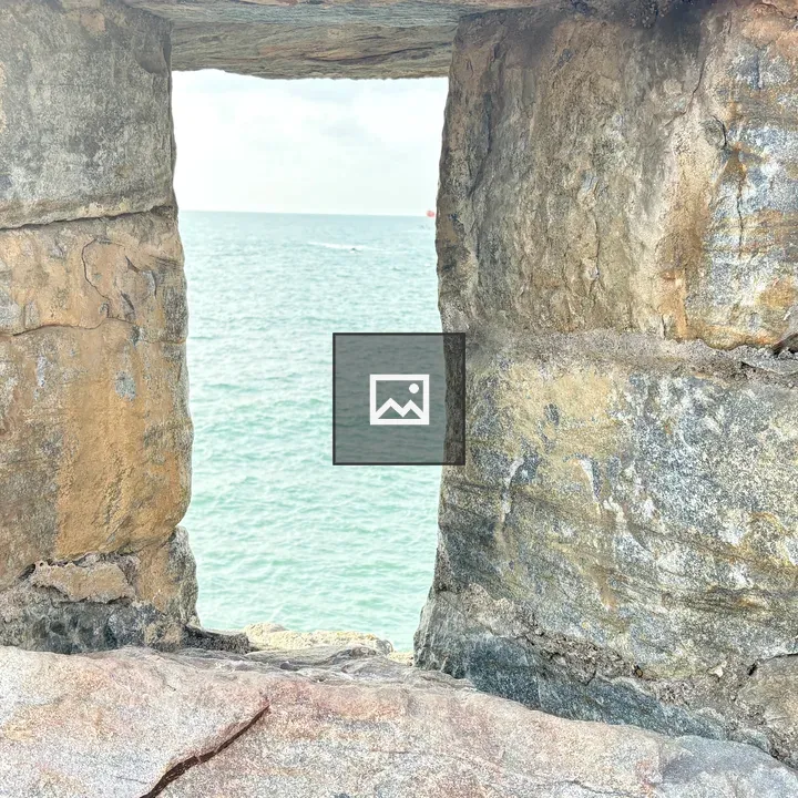 Weathered stone wall with blue water