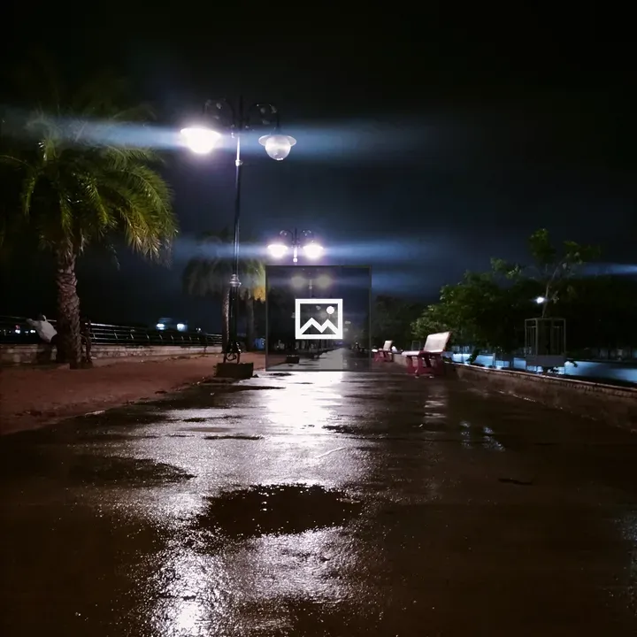 Wet road at night with lamppost reflections