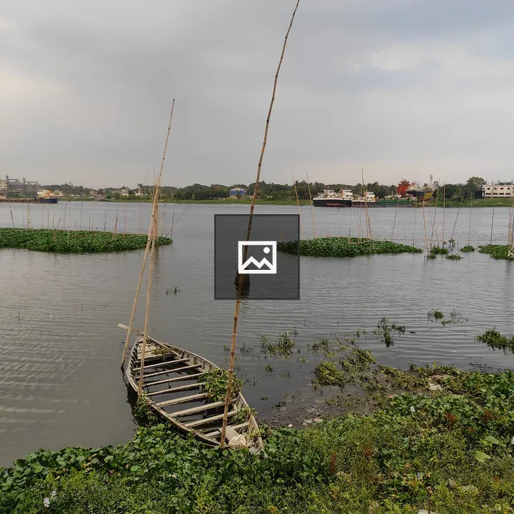 Weathered wooden boat by river