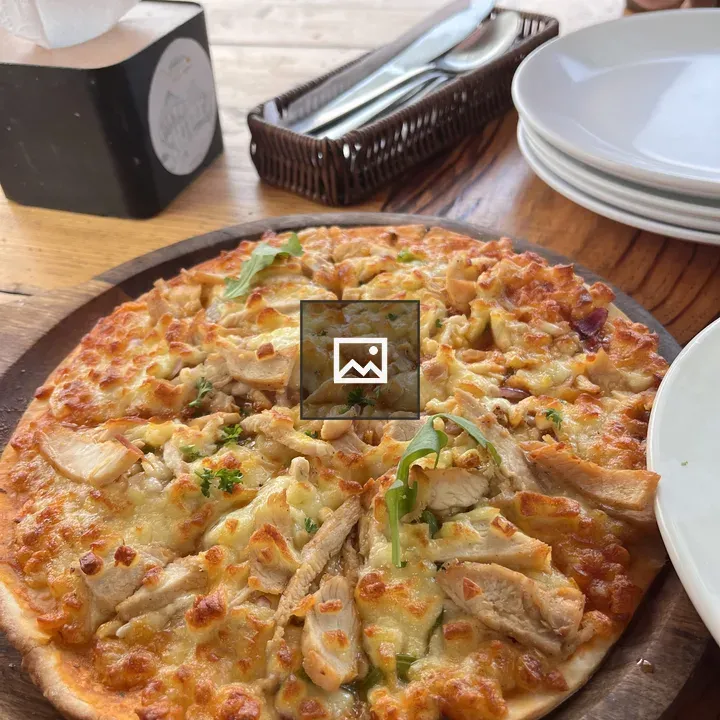 Pizza on wooden board with arugula