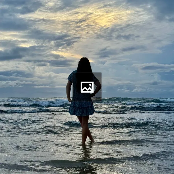 Person in blue dress at dawn beach