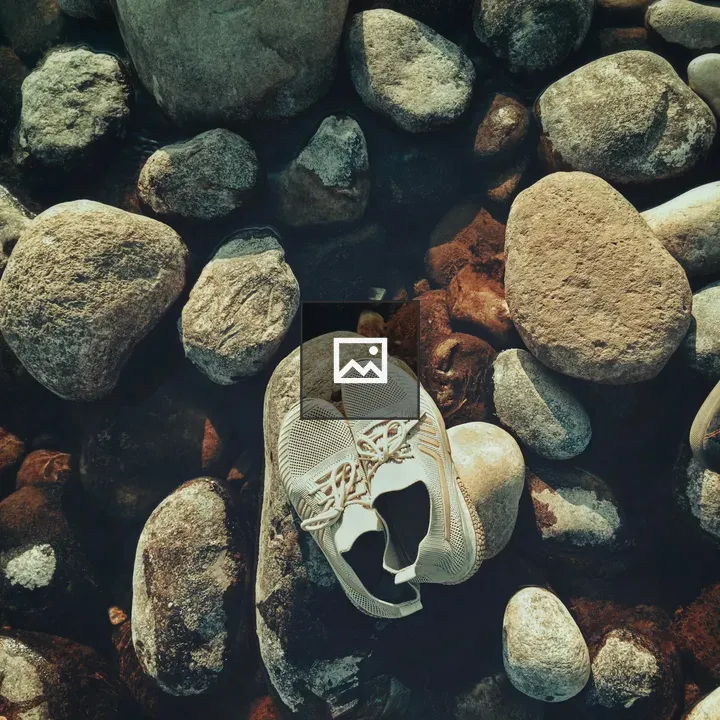 White sneakers on rocks above water
