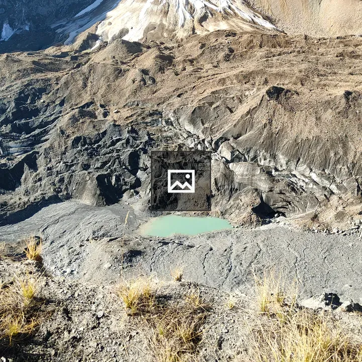 Barren mountain landscape with emerald pond