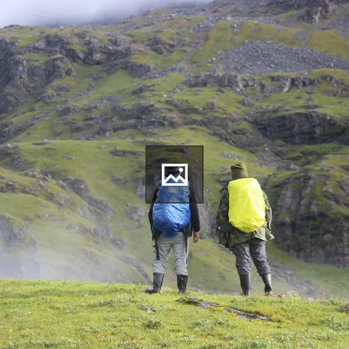 Two hikers on grassy hillside