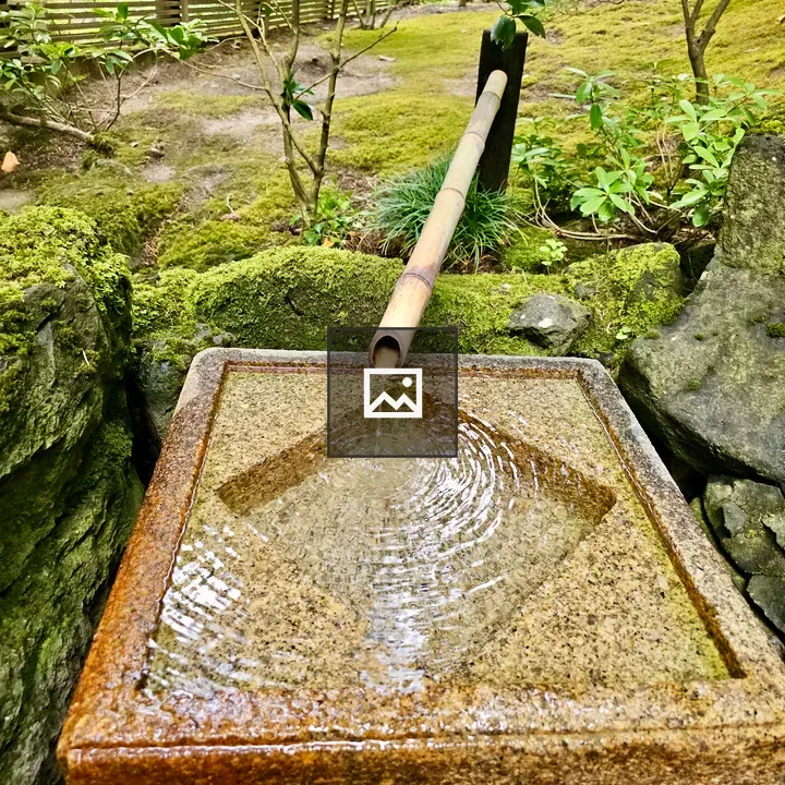 Stone water basin with bamboo pipe