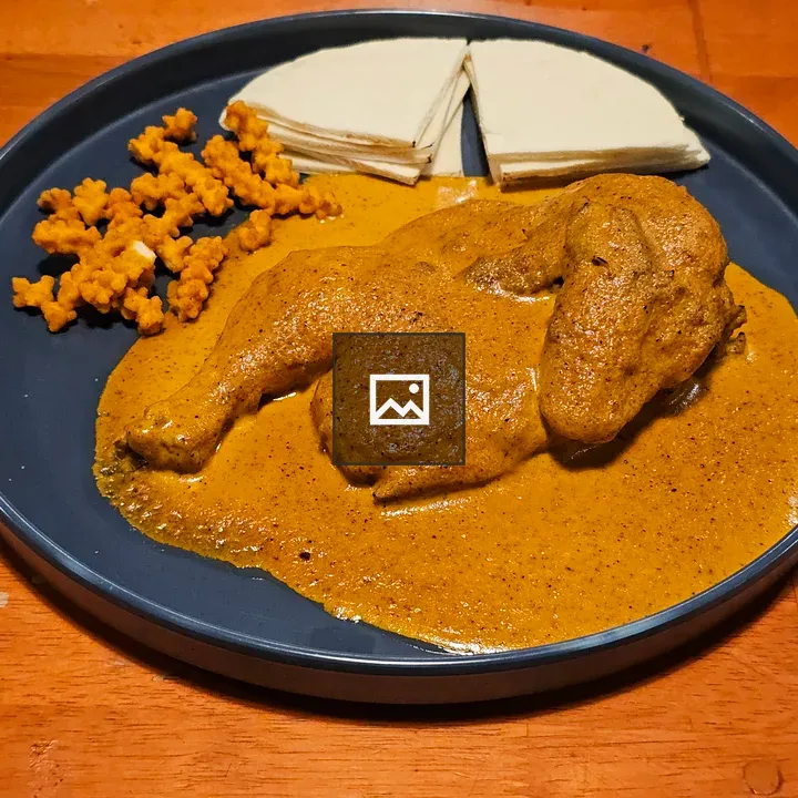 Plate of chicken curry with flatbreads