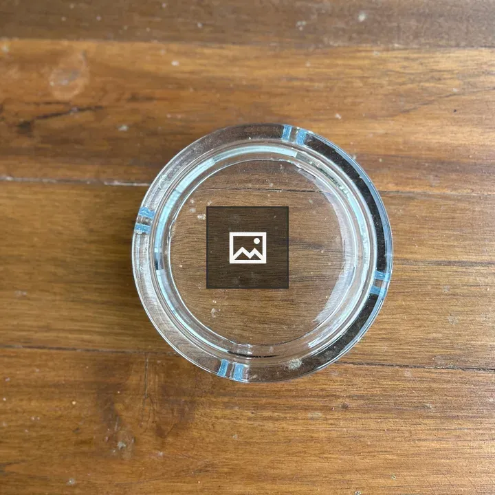 Clear glass ashtray on wooden tabletop