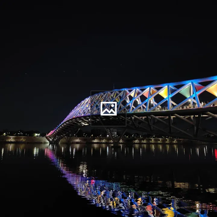 Pedestrian bridge at night with reflections
