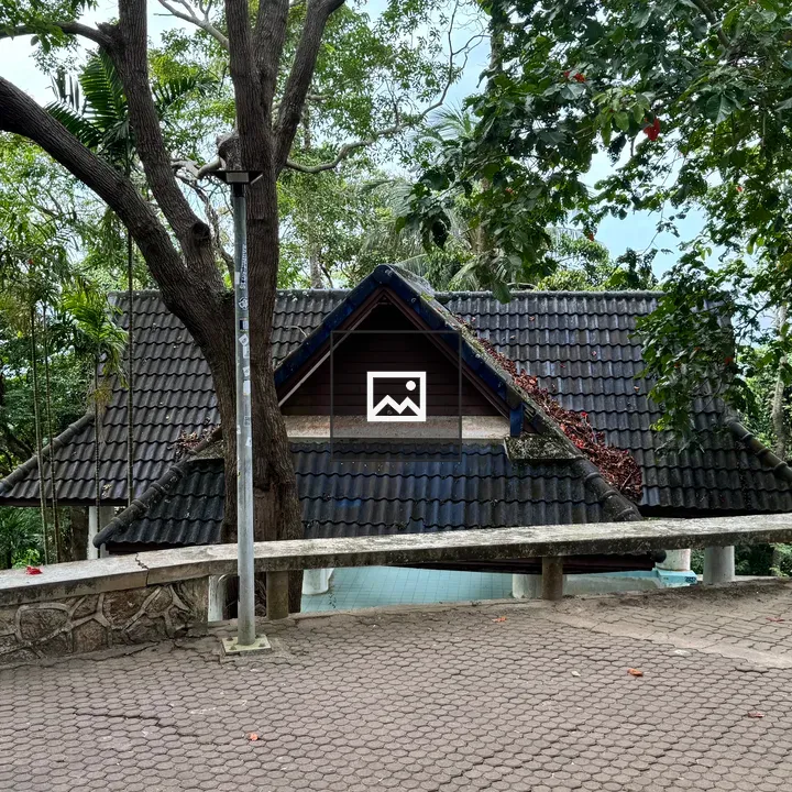 House with Dark Tiled Roof on Sloped Path
