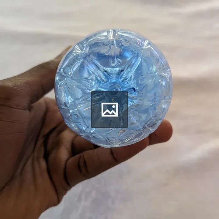 Hand Holding Light Blue Circular Object