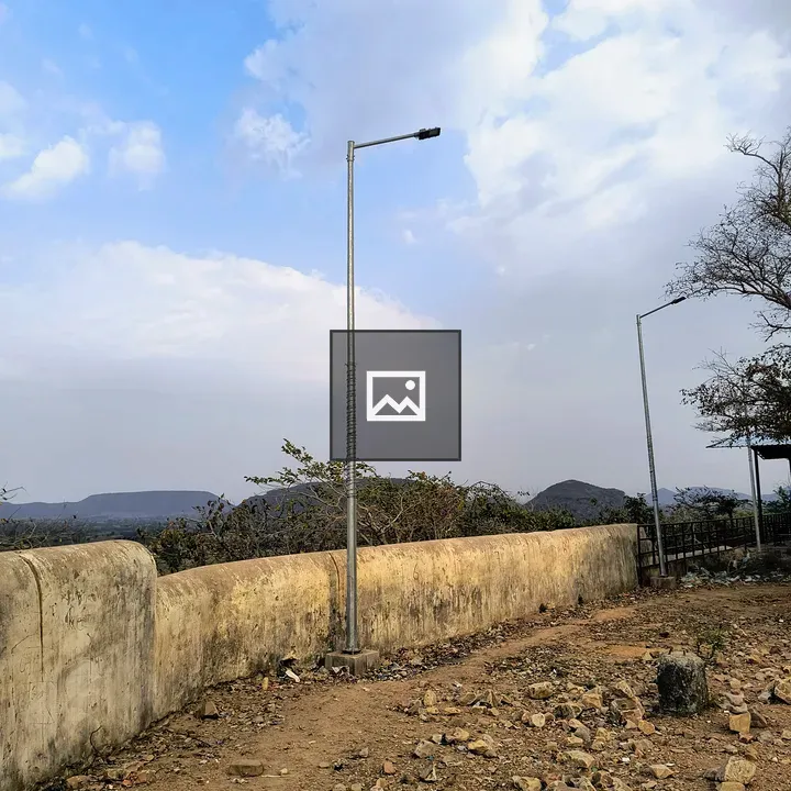 Two streetlights with cloudy sky