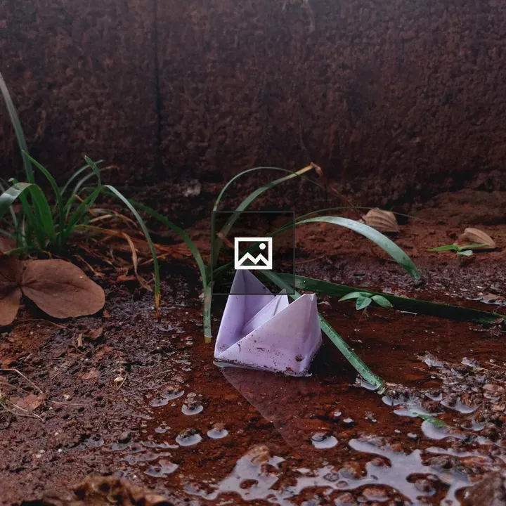 Paper boat in puddle after rain