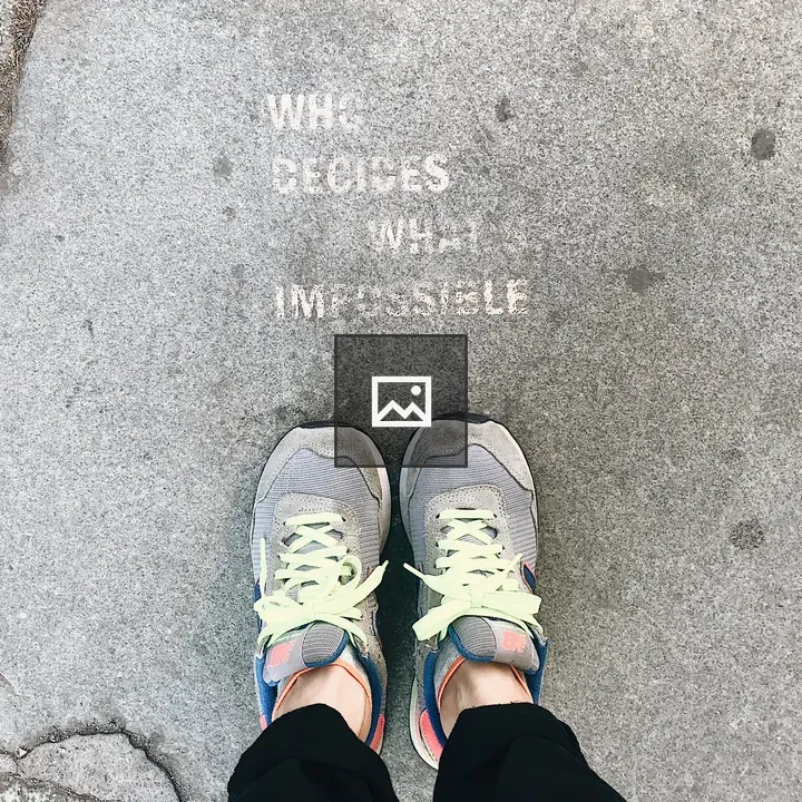 Person in front of spray-painted message