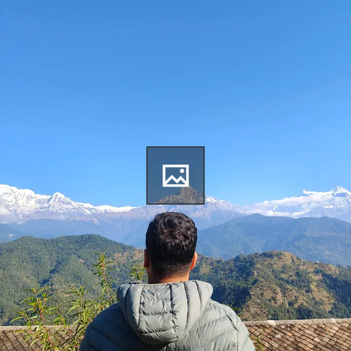 Person in gray puffer jacket overlooking mountain landscape