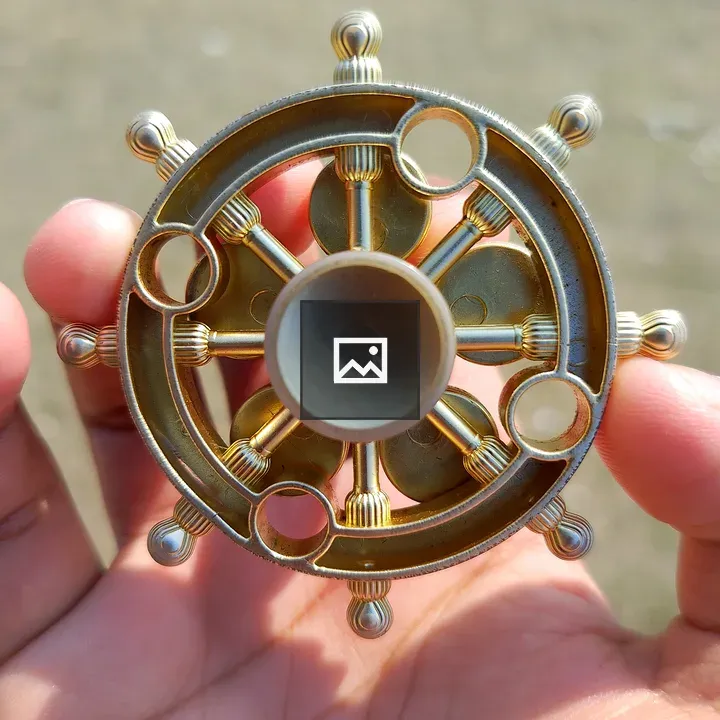 Detailed circular metal object held by a person