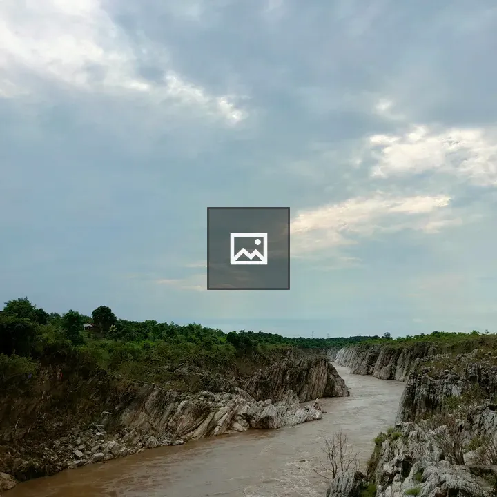 Muddy river beside rocky cliffs