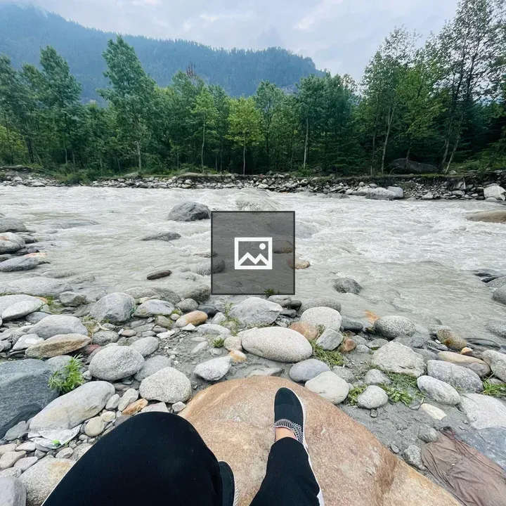 Feet and legs on rocks by stream