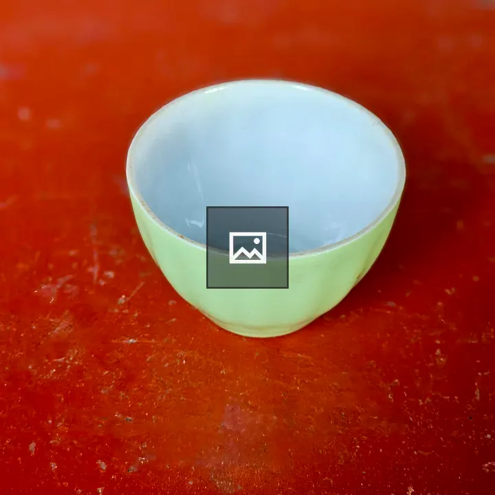 Green ceramic cup on red table
