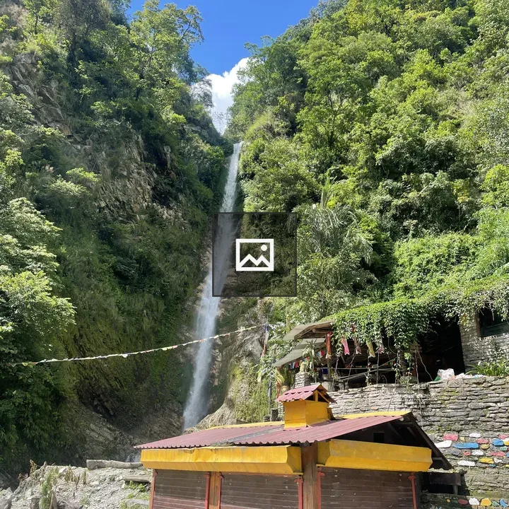 Waterfall Near Stone Wall and Flags