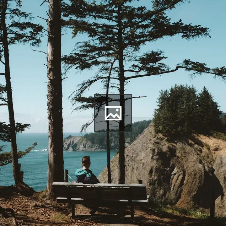 Person on bench overlooking cliff coast