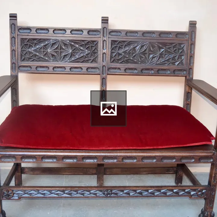 Vintage wooden settee with red cushion