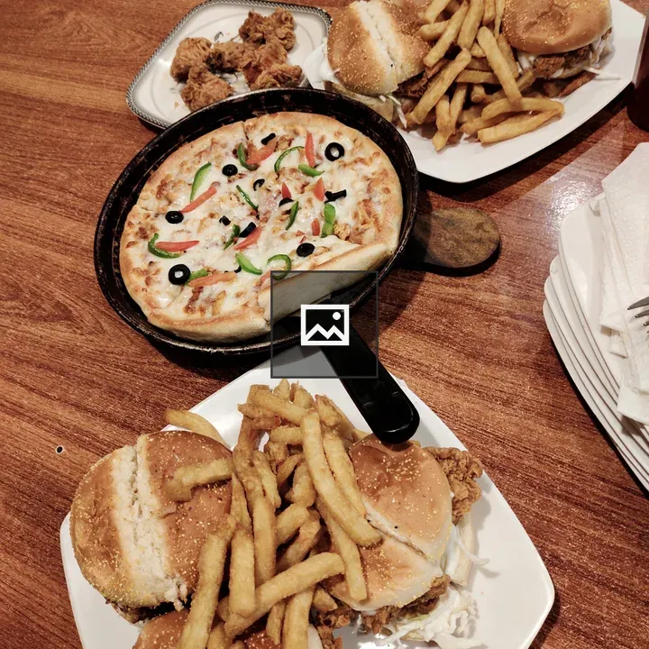 Table with pizza, fried chicken, and buns