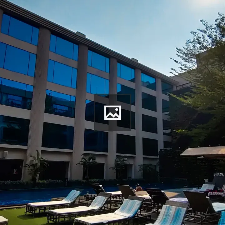 Lounge chairs by pool and high rise