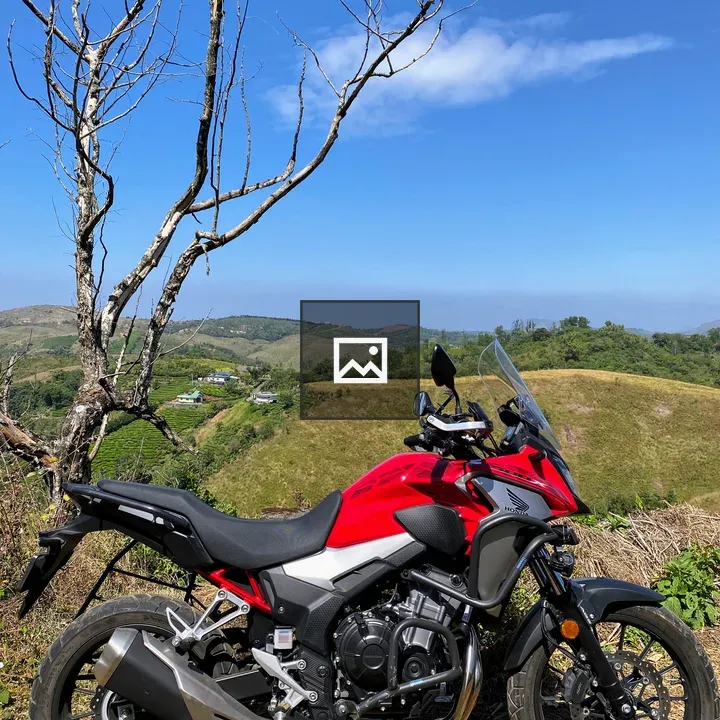 Red motorcycle with hills backdrop