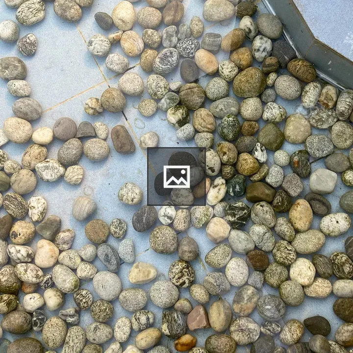 Multicolored pebbles on blue tiled surface