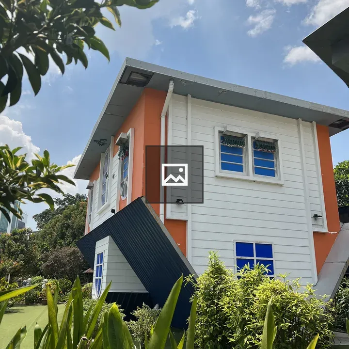 Tilted orange and white house with blue windows