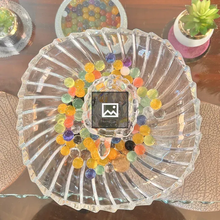 Glass dish with marbles on glass table