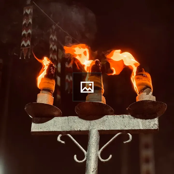 Three flaming vilakku torches