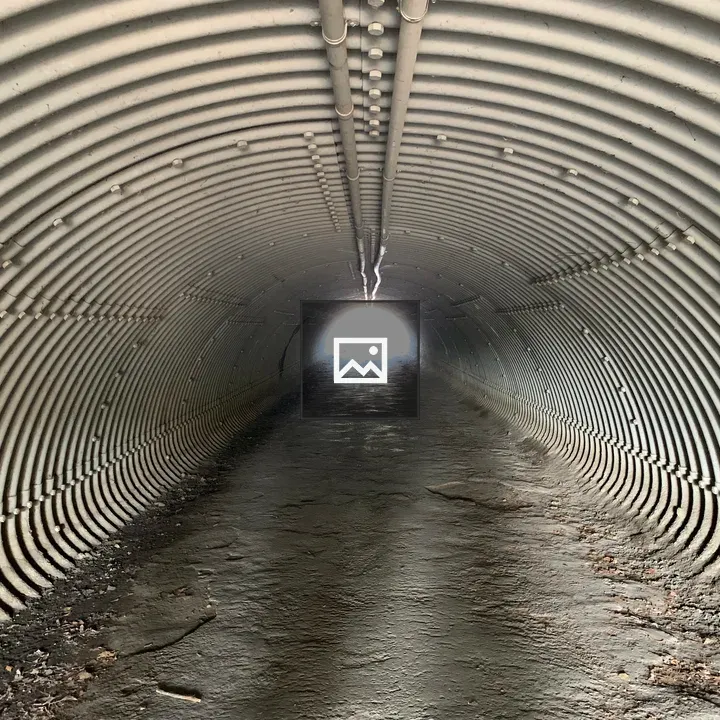 Concrete Path Through A Metal Tunnel