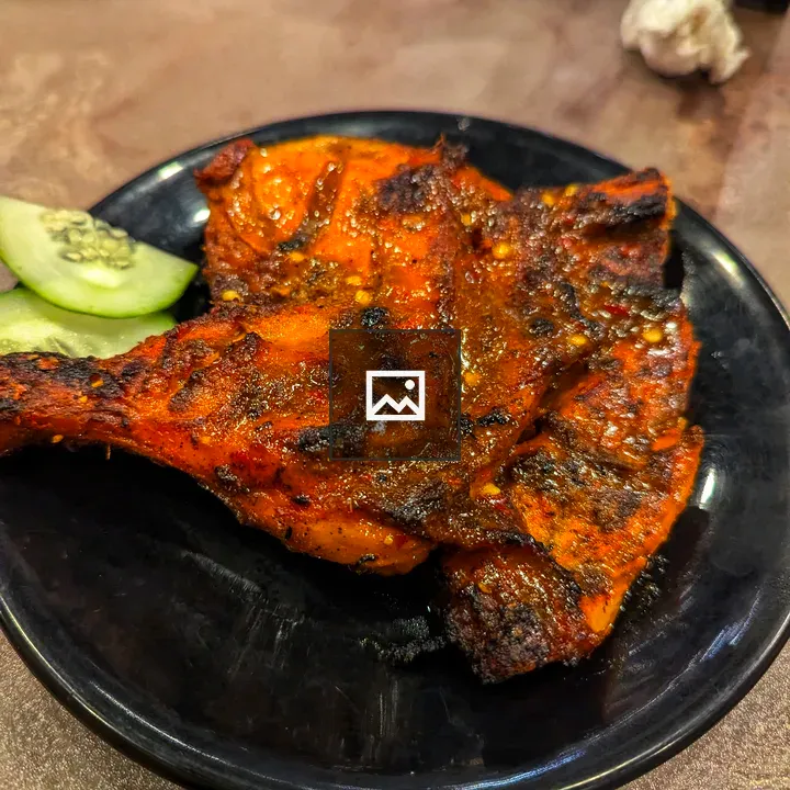 Grilled chicken pieces on black plate