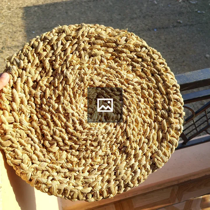 Hand holding woven straw mat