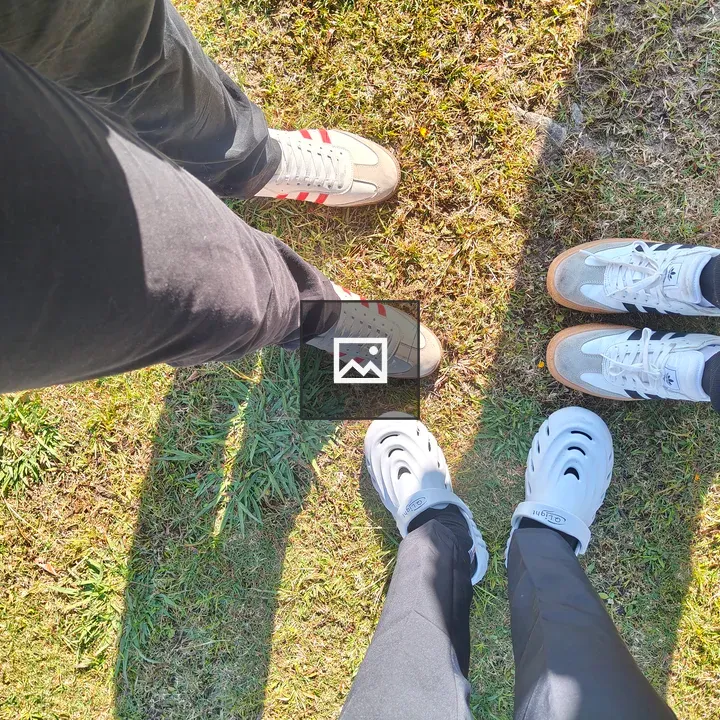 Three pairs of shoes on grass