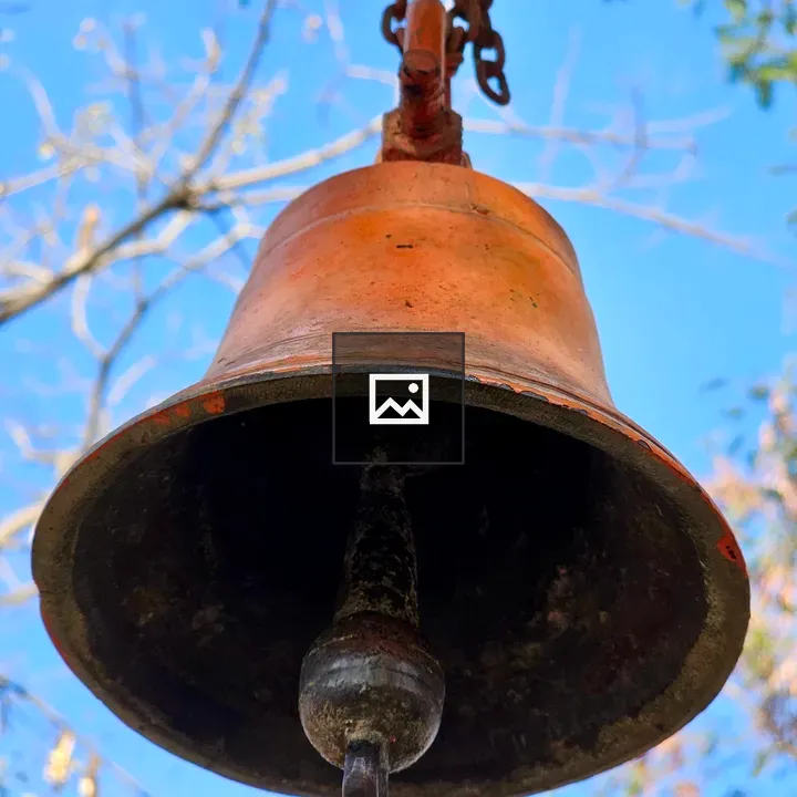 Rusty bell hanging from chain