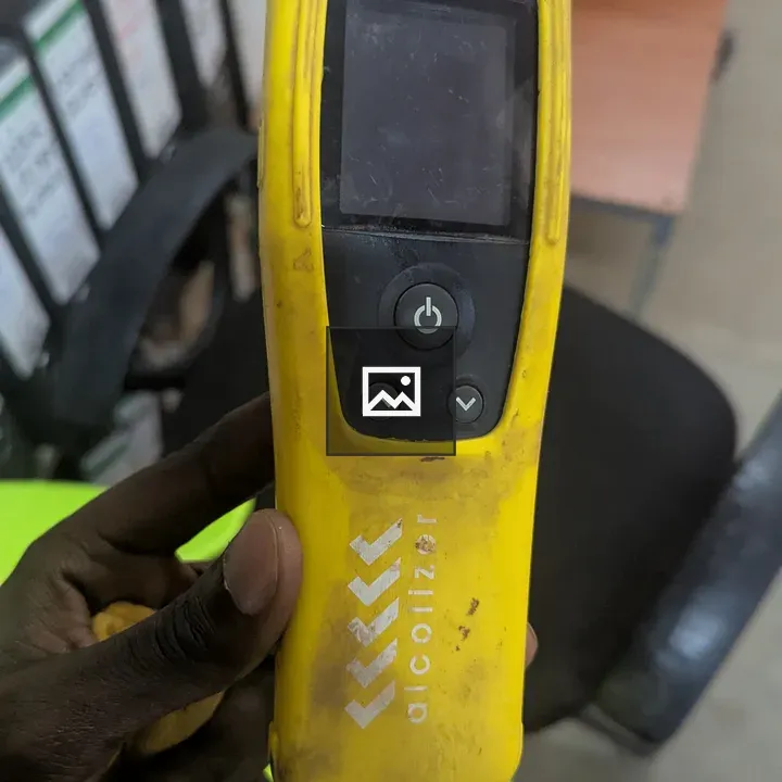 Person holding yellow breathalyzer
