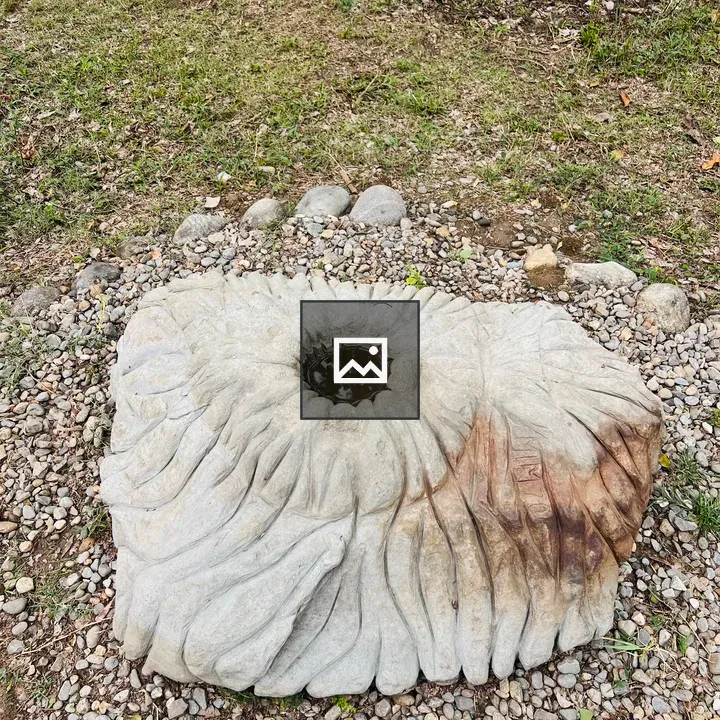 Stone flower sculpture on pebbles