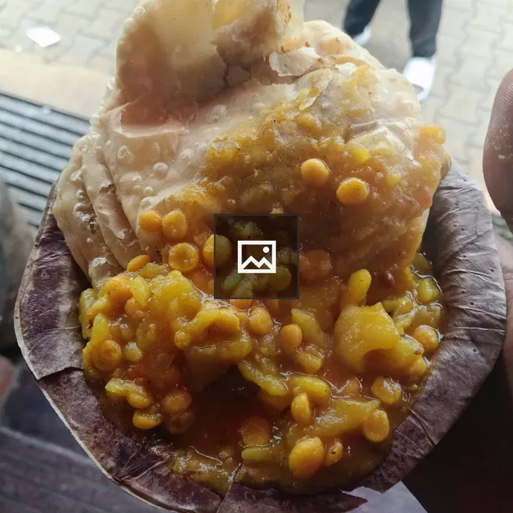 Puri with yellow lentil curry on leaf plate
